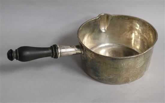 An early 19th century French silver brandy pan, with turned wooden handle, gross 13oz.